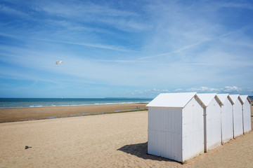 Traditional white wooden beach cabins on the beach of Villers, Normandy, France