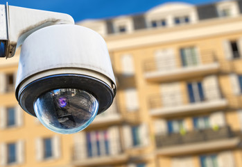 security CCTV camera or surveillance system with modern luxury residence on blurry background