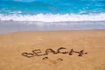 Inscription beach on the sand. Beach season. Rest on the sea