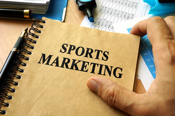 Hands holding book with title sports marketing.