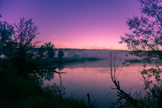 A misty morning over the river. Pink dawn over the river. Rural landscape