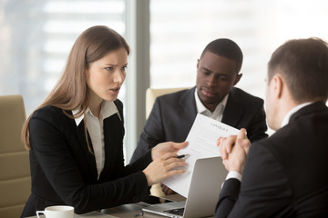 Angry dissatisfied businesswoman holding contract arguing with contractor, pointing at terms failed...