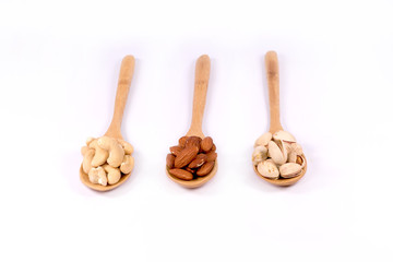 Delicious almond nuts,cashew and pistachio in wooden spoon  on white background.