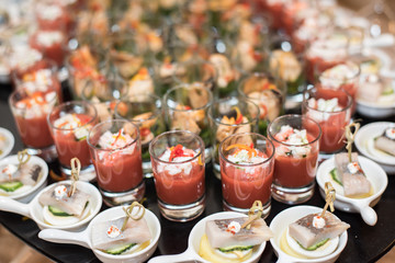 Cold seafood snacks in glasses and plates