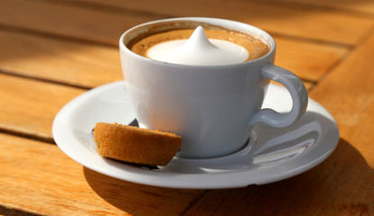 Cappuccino mit Keks lecker serviert auf Holztisch 