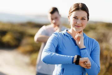 Obraz premium Runner woman with heart rate monitor running on beach