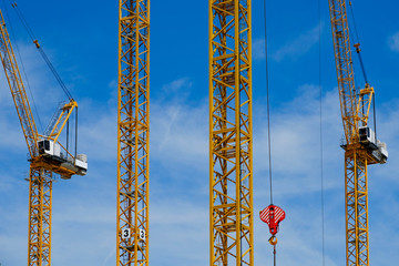 yellow construction cranes on blue sky 