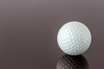 Close up the new white golf ball with the reflection, sport concept.