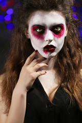 Young woman in color contact lenses, with Halloween makeup at party, closeup