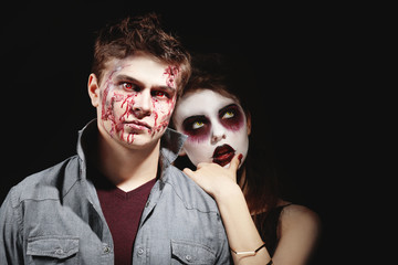 Obraz premium Young people in color contact lenses, with Halloween makeup on black background