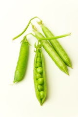 Pea pod and pea seeds on white