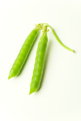 Pea pod and pea seeds on white