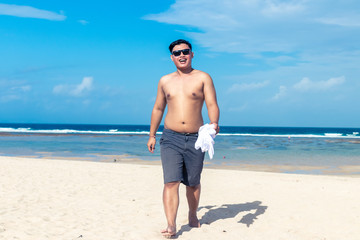 Young asian indonesian man on the beach of tropical Bali island, Indonesia.