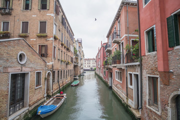 Fototapeta premium Widok na gondolę wraz z budynkiem wzdłuż kanału w Wenecji.