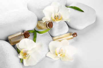 Obraz na płótnie Canvas Spa stones with orchid flowers and aroma oil, closeup