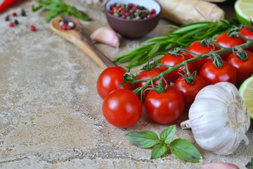 Food background with different ingredients on a marble background. Cherry tomatoes, rosemary, garlic, pepper, lime. Top view.