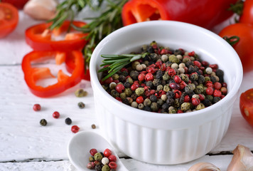 White wooden background with spices, pepper and rosemary. Ingredients for cooking. Top view.
