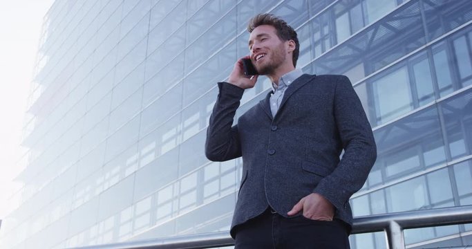 Smart phone man calling on mobile phone in city business district. Confident young business man talking on smartphone smiling happy wearing suit jacket outdoors. Urban male professional in 20s.