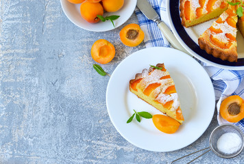 Homemade cake with apricots and nectarines on a concrete background.