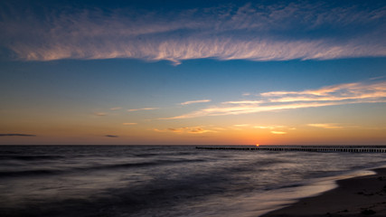 Fototapeta na wymiar Beginn Sonnenaufgang am Strand über dem Meer