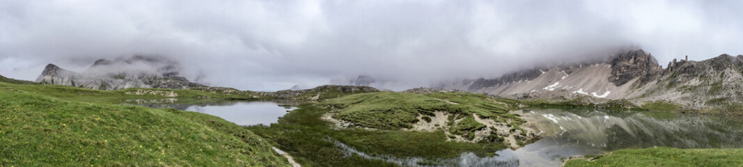 Fototapeta na wymiar Panoramic view of lake and mountain on a cloudy day, Italian Dolomites