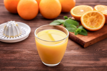 Glass of fresh orange juice on wooden table