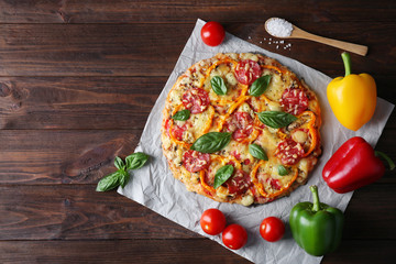 Composition of tasty pizza, vegetables and spoon on wooden background