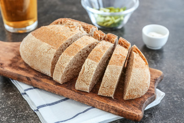 Wooden cutting board with sliced loaf of beer bread on table