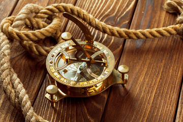 Compass and rope on wooden table. close up