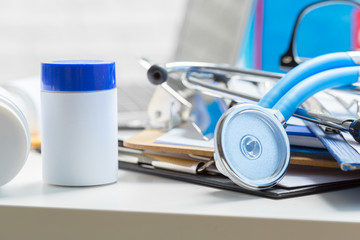 Stethoscope lying on medical form on clipboard .
