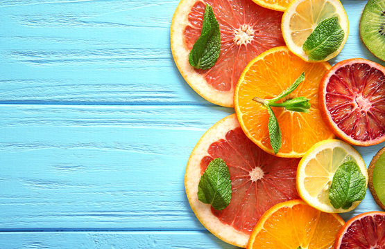 Citrus slices on color wooden  background