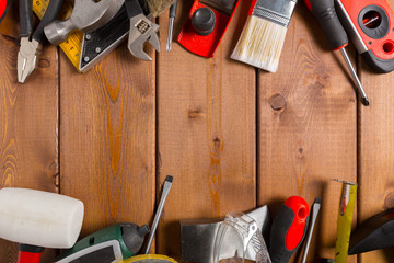 Assorted work tools on wood background