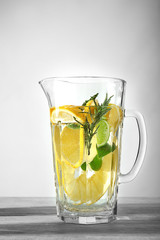 Jug with fresh lemonade on table
