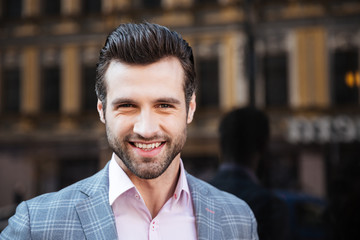 Smiling handsome man in a jacket looking at camera