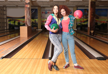 Friends having fun and playing bowling