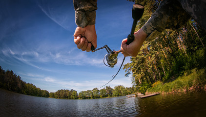 Fishing buckground. Fisherman with spinning on the lake.