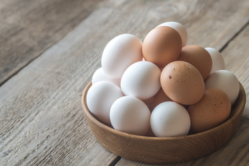 Wooden bowl of raw chicken eggs