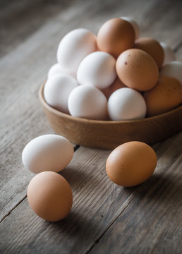 Wooden bowl of raw chicken eggs