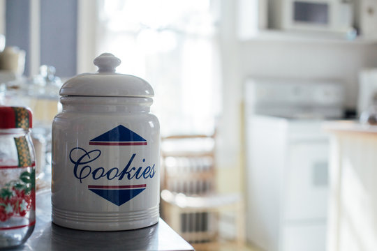 Huge white cookie jar on the kitchen shelf of typical american house, with pastries and sweet treats, in beautiful light interior design