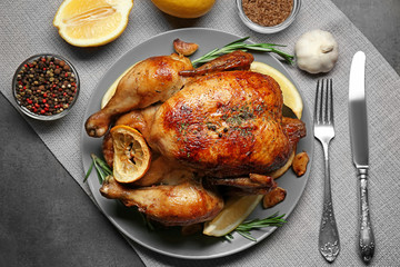Homemade baked chicken with lemon and rosemary on table