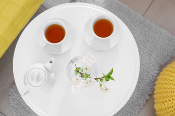 Tea set and beautiful flowers on table at home