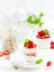 Dessert in a glass with granola, yogurt and strawberries. Useful breakfast.