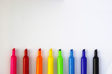 Rainbow colored marker tips on white background
