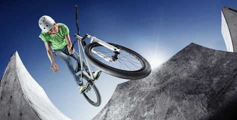 Extrem Sport. Boy jumping with his street-bike in the extreme park.