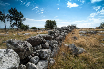 The old fence with stacked stones in a long row, where in ancient times cows, horses and sheep walked around and grazed