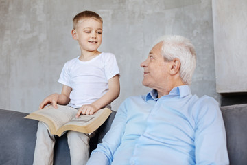 Smart curious boy chatting with his grandpa