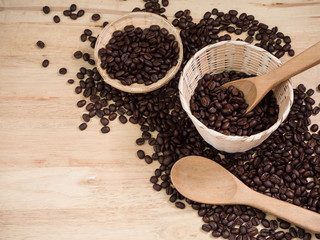 coffee beans in basket weave and wood spoon on wood table