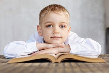 Lovely vibrant boy fulfilling his home assignment