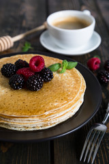 Thin pancakes with fresh berries and coffee