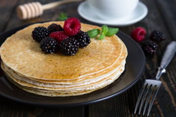 Thin pancakes with fresh berries and coffee